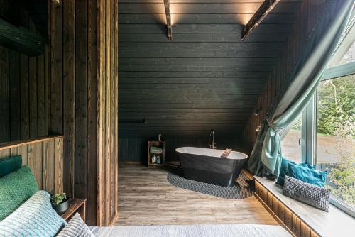 a bathroom with a bath tub and a window at SOPRANO - 'Virš Ąžuolų' - Forest SPA - FREE jacuzzi in Paplatelė