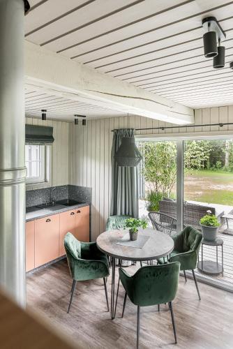 a kitchen with a table and chairs on a patio at SOPRANO - 'Virš Ąžuolų' - Forest SPA - FREE jacuzzi in Paplatelė