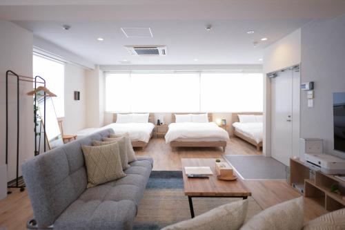uma sala de estar com um sofá e uma mesa em RIVER VILLAS HIROSHIMA em Hiroshima