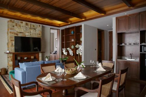 a dining room with a table and a blue couch at Plataran Bromo in Ngadiwano