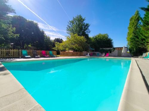 a large blue swimming pool with chairs in a yard at Domaine Jasmin, 6 Gîtes typiquement Charentais avec Piscines in Bellon
