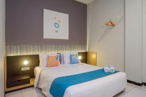سرير أو أسرّة في غرفة في Sans Hotel Good Wish Semarang