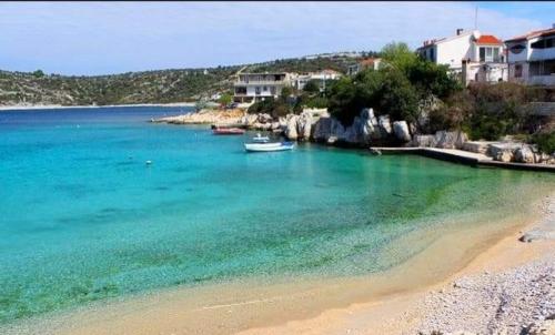 a view of a beach with boats in the water at Kopara apartmanok in Rogoznica
