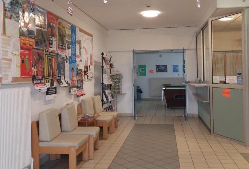 poczekalnia z krzesłami i plakatami na ścianie w obiekcie Auberge de jeunesse HI Poitiers w mieście Poitiers