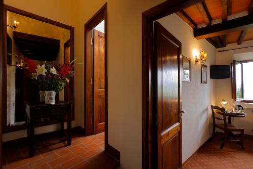 a hallway with a door and a vase of flowers on a table at Relais Vignale & Spa in Radda in Chianti