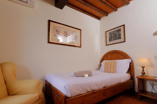 a bedroom with a bed and a chair with a stuffed animal on it at Relais Vignale & Spa in Radda in Chianti