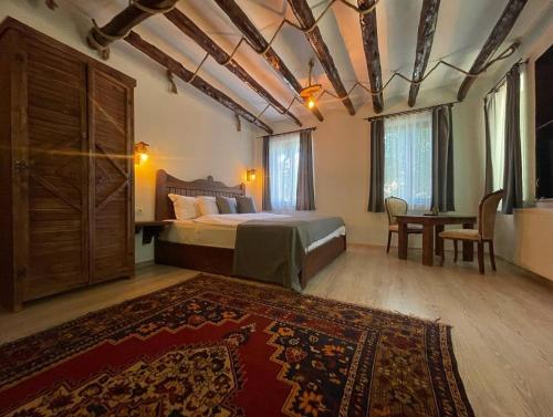 a bedroom with a bed and a table and a rug at Kapadokya Konak in Uçhisar