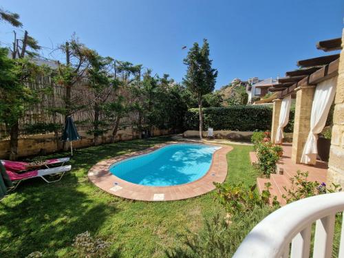 a swimming pool in the yard of a house at Rock House's Villa Melody in Plataniás