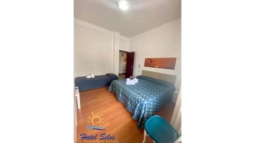 1 dormitorio con cama y colcha azul en Hotel Silvi en Silvi Marina