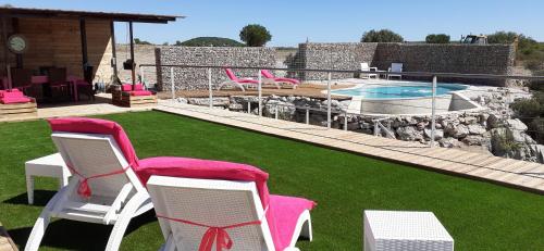 une cour avec des chaises, une piscine et une maison dans l'établissement Les Caselles de Marie, à Aumelas