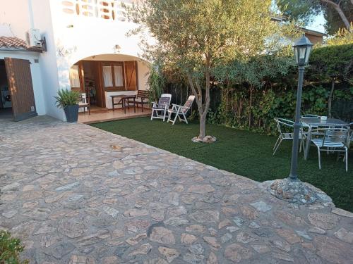een patio met een tafel en stoelen in een tuin bij Casa katy in L'Escala