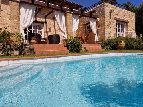 a large swimming pool in front of a house at Rock House's Villa Melody in Plataniás