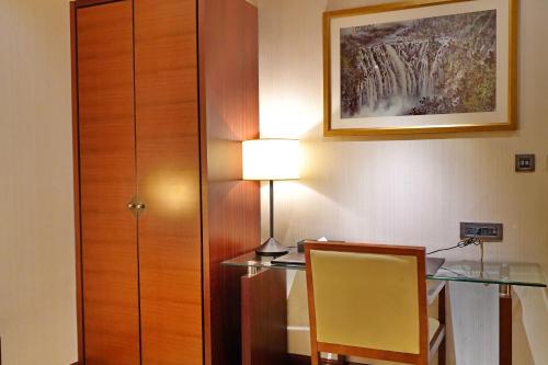 a desk with a lamp and a table with a chair at Hù House - Taipei in Taipei