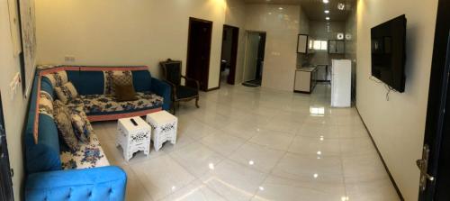 Il comprend un salon avec un canapé bleu et une cuisine. dans l'établissement وحدات سكنية الحصون, à Ithnayn