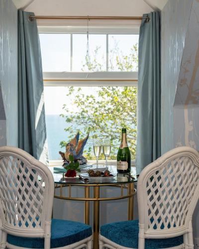 a table with two chairs and a bottle of wine at Enchanted Manor in Niton