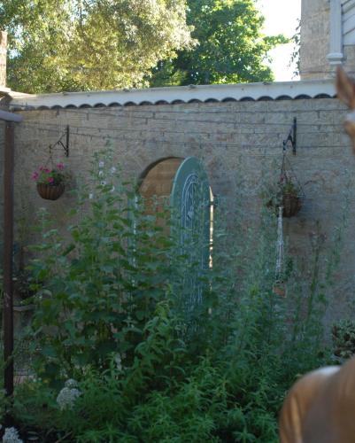 a stone wall with a gate and a garden at Enchanted Manor in Niton