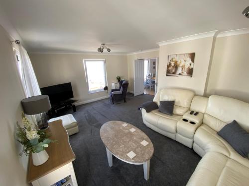 a living room with a couch and a table at Eastcliffe Penthouse, 2 beds & bathrooms with parking in Cleethorpes