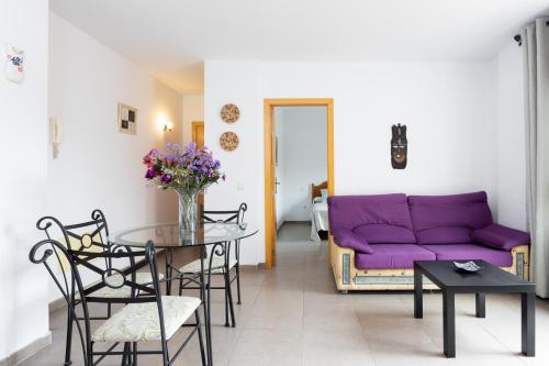 - un salon avec un canapé violet et une table dans l'établissement Home2Book Cozy Apartment La Lajita, à Lajita
