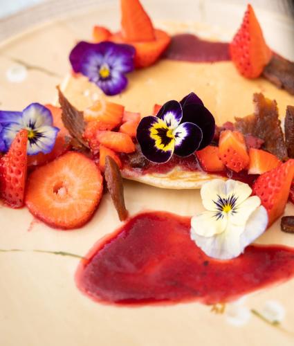 a dessert with fruit and flowers on a plate at Enchanted Manor in Niton