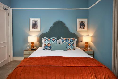 a bedroom with a large bed with blue walls at Hotel du Vin Winchester in Winchester