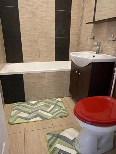 a bathroom with a toilet and a sink and a tub at Apartament SweetHome Piața Unirii in Iaşi