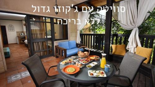 a table with breakfast food on a balcony at Eden's Boutique in Had Nes