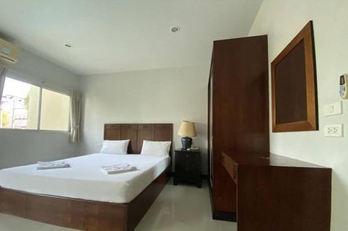 a bedroom with a large bed and a window at C.A.P Mansion in Phuket Town
