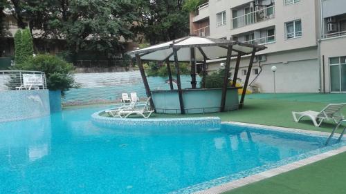 - une piscine avec un kiosque à côté d'un bâtiment dans l'établissement 1 room in Nikea Park apartaments, aux Sables d'or