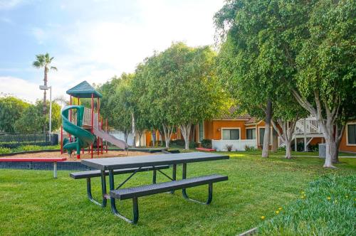 a picnic table in a park with a playground at Clementine Hotel & Suites Anaheim in Anaheim