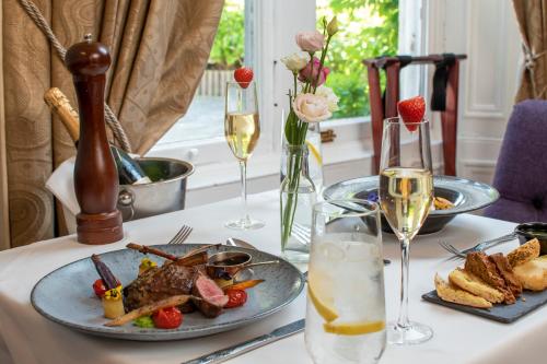 a table with a plate of food and glasses of wine at Newpark Hotel in Kilkenny
