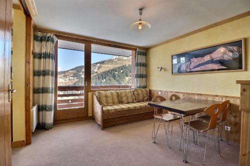 a living room with a couch and a table with chairs at Residence Plein Soleil in Méribel