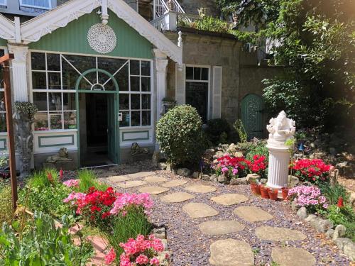 a garden with flowers in front of a house at Enchanted Manor in Niton