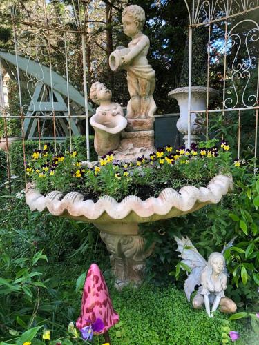 a garden with a statue of two children and a fountain at Enchanted Manor in Niton