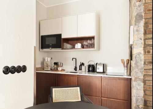 a kitchen with wooden cabinets and a microwave at 46heima Boutique Apartments in Reykjavík