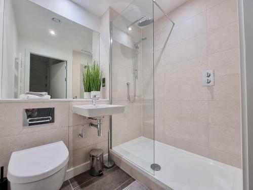 a bathroom with a toilet and a sink and a shower at Stunning 4-bedroom Townhouse with Free Parking in Manchester