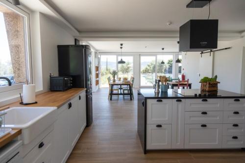 a kitchen with white cabinets and a black refrigerator at Quinta da Sra Marocas in Covilhã