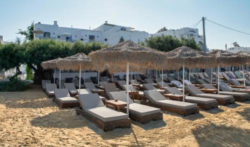 a bunch of chairs and umbrellas on a beach at Castello studios in Agia Anna Naxos