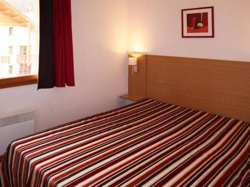 une chambre avec un lit avec une couverture rayée dans l'établissement Appartement 3 pièces, piscine, jacuzzi, 8 pers, Les Orres 1800 - FR-1-322-429, aux Orres
