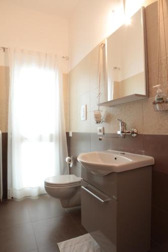 y baño con lavabo, aseo y espejo. en Terra Oltre B&B, en Trepuzzi