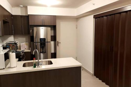 a kitchen with a sink and a refrigerator at Altamira Cozy apartment with amazing views in Santo Domingo
