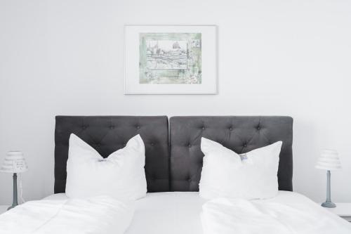 ein Bett mit weißer Bettwäsche und weißen Kissen in der Unterkunft Hotel Aurora in Kappeln