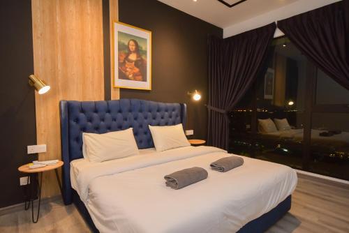 a bedroom with a large bed with two pillows on it at Midvalley Southkey Mosaic Suite by Nest Home in Johor Bahru