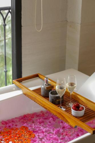 a tray with two glasses of wine and flowers at Plataran Bromo in Bromo