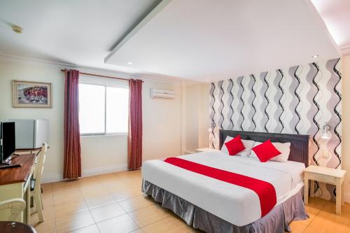 a bedroom with a large bed with red pillows at Hotel Euroasia By BLUEBOOKERS in Angeles