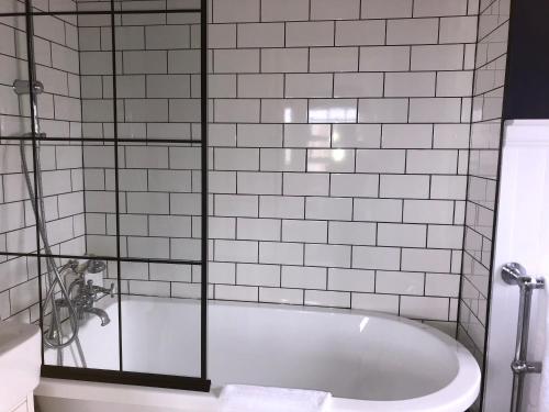 a bathroom with a tub with a glass shower backdoor at SEAFRONT SANCTUARY Beautiful Art Deco Apartment with Stunning City & Sea Views in Brighton & Hove