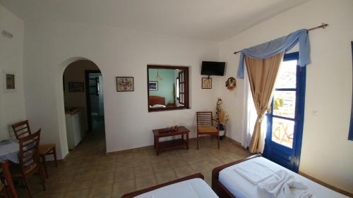 a bedroom with a bed and a table and a window at Aegean Star Hotel in Karavostasi