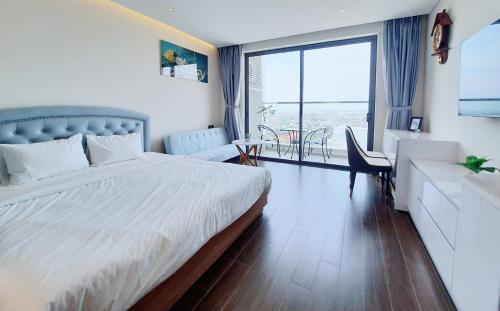Habitación de hotel con cama, escritorio y mesa. en Beach Condotel - Apec Phú Yên, en Tuy Hoa