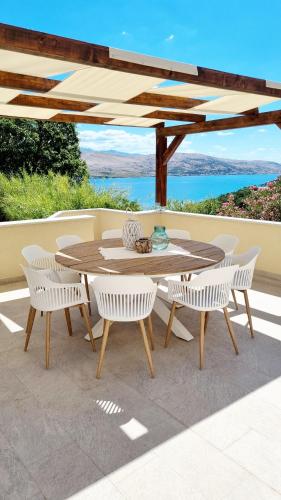 a wooden table and chairs on a patio at Salt & Stone Villa in Pag