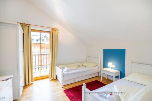 a bedroom with two beds and a window at Schönblick Mountain Resort & Spa - Das Original! in Rauris
