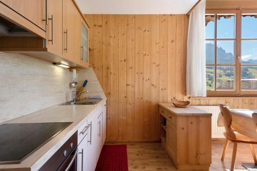 a kitchen with wood paneling and a large window at Paracia App Pec in Badia